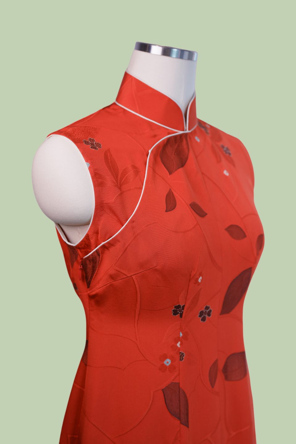 Christmas red sleeveless Qipao with trailing leaf motifs and contrast ivory rope piping